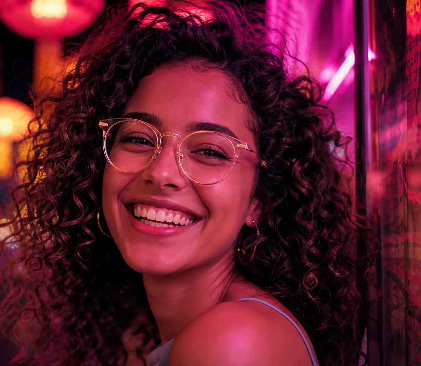 Smiling woman with curly hair in clear round eyeglasses
